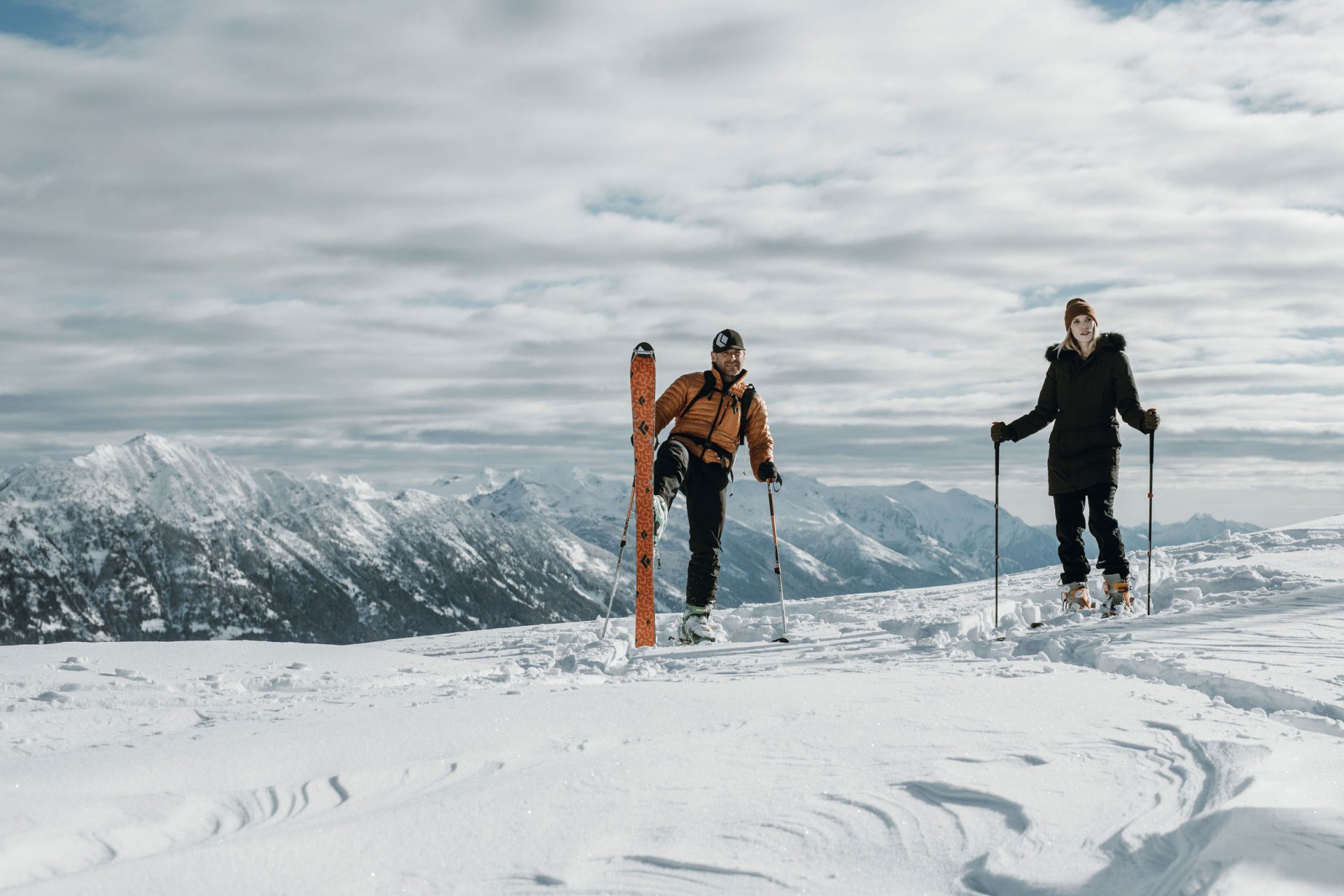 Two people skiing with the Cascade mountains in the background